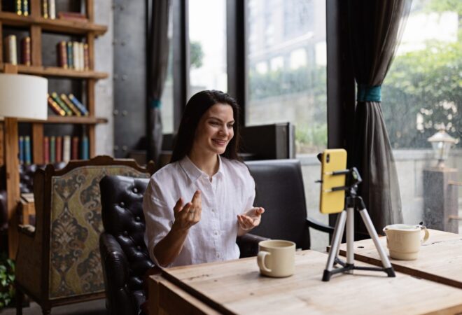 Happy Young Caucasian Influencer Using Mobile Phone in Cafe